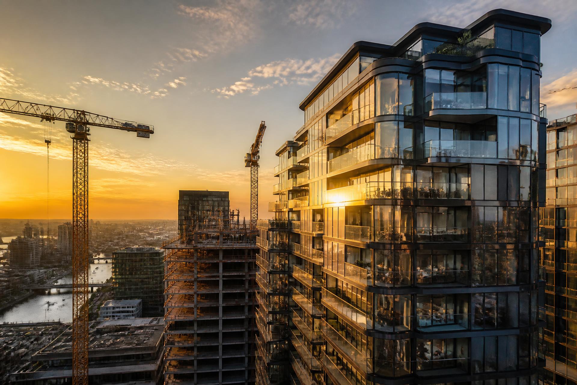 Modern apartment towers under construction at golden hour